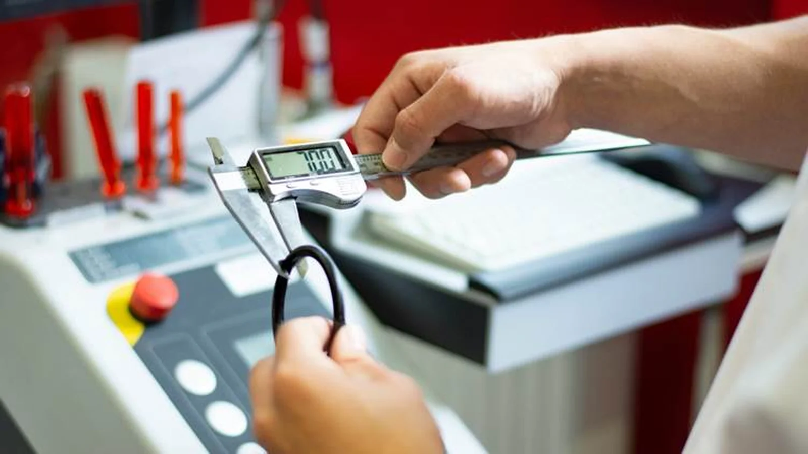 Engineer using a digital caliper to inspect a manufactured component